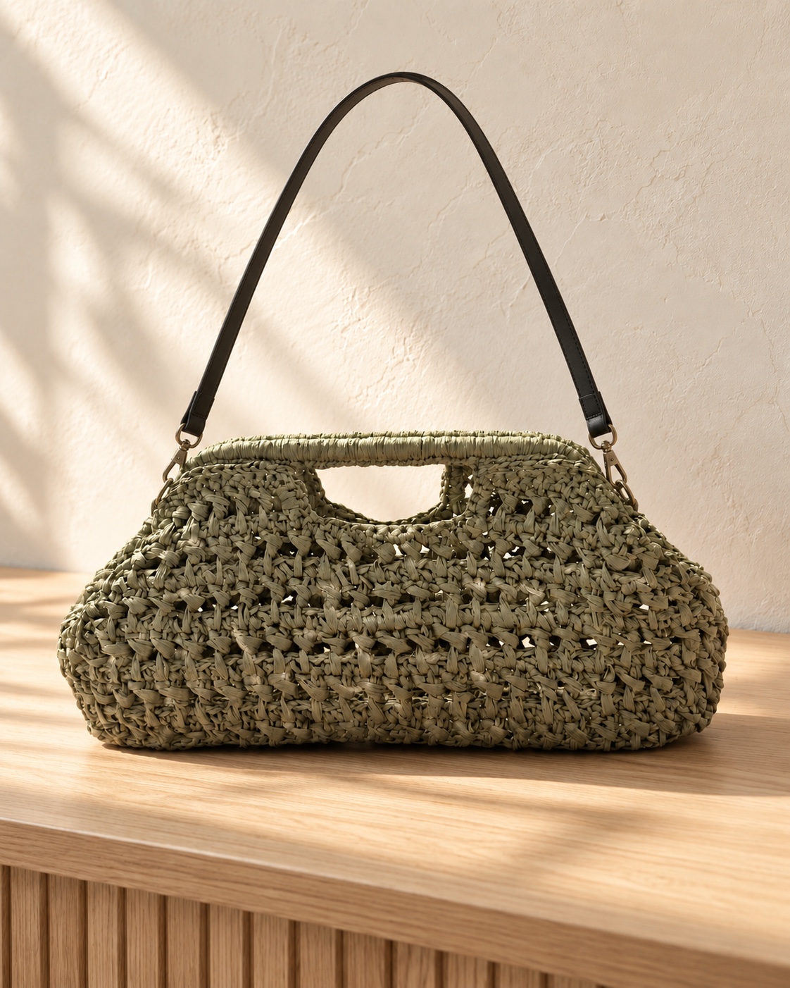 Olivgrüne Tasche mit offener Struktur, integriertem Griff und dunklem Schulterriemen.